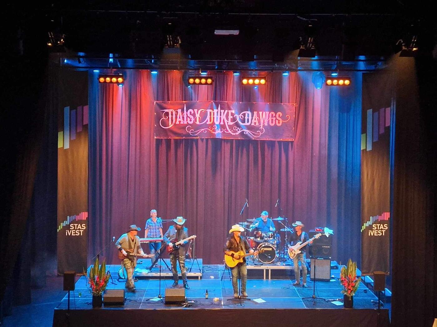 Bandet på scenen med Daisy Duke Dawgs-banner